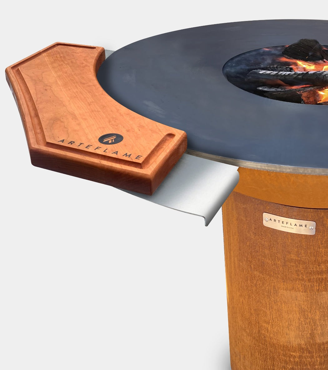 Side warming table and wood cutting board on an Arteflame cooktop