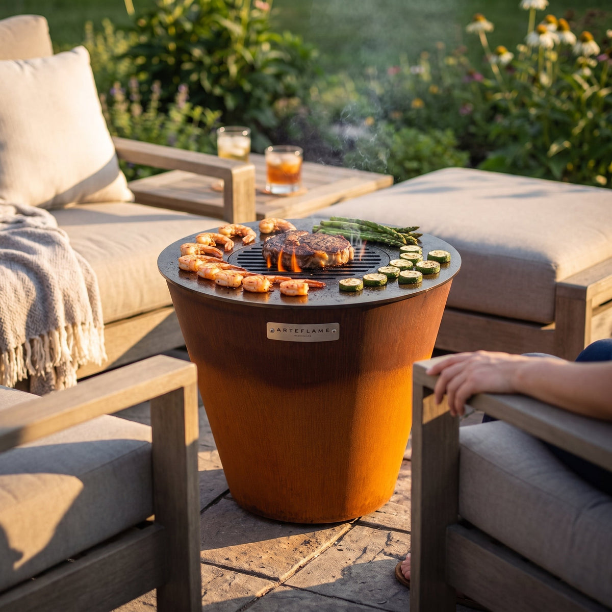 Arteflame ONE20 between two lounge chairs on a small patio